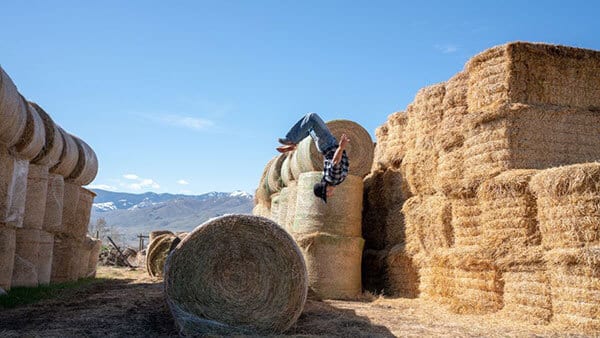Lance Pekus doing a flip off of hay bales on his ranch